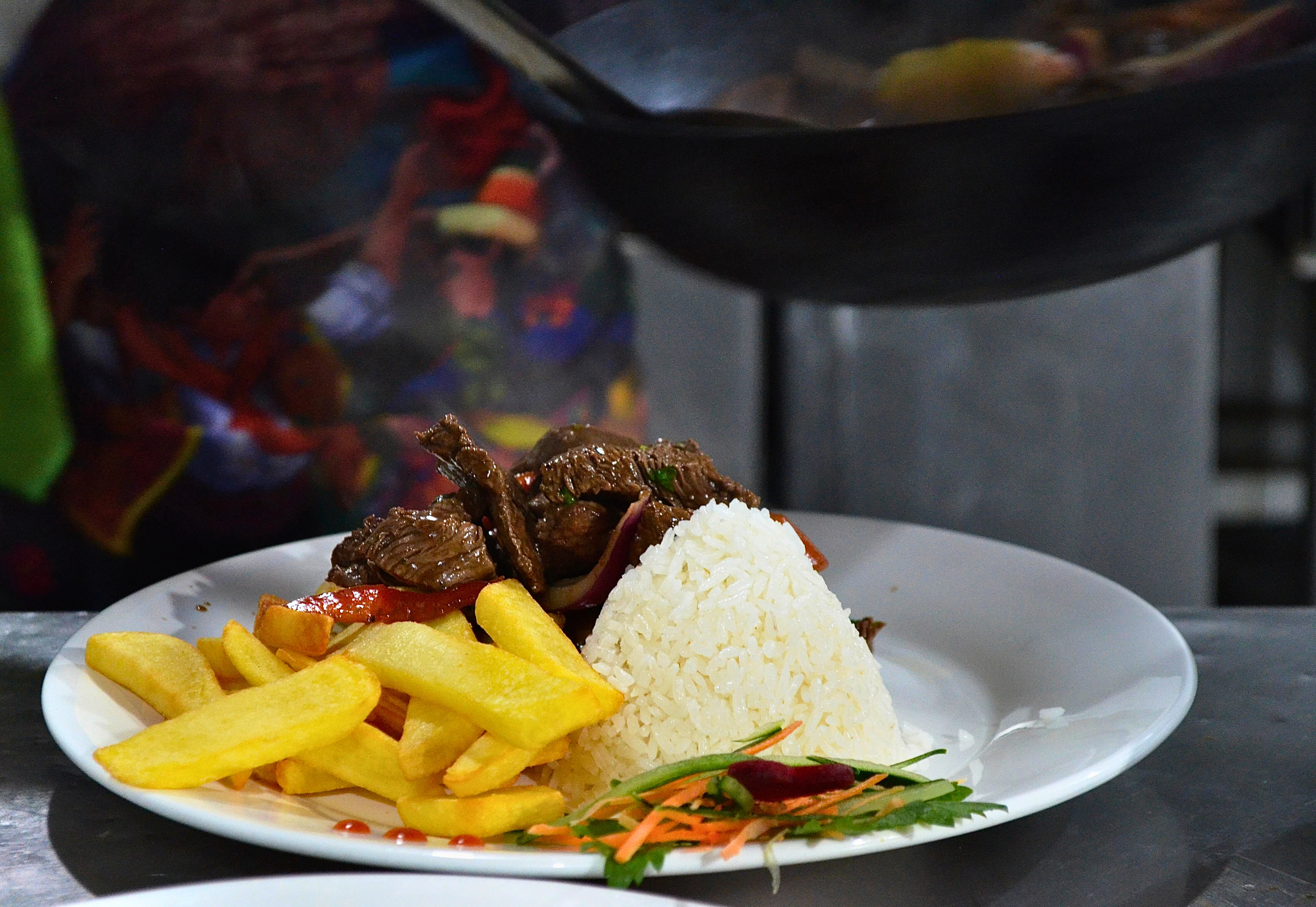 Preparación de lomo saltado en la cocina de Manos Peruanas
